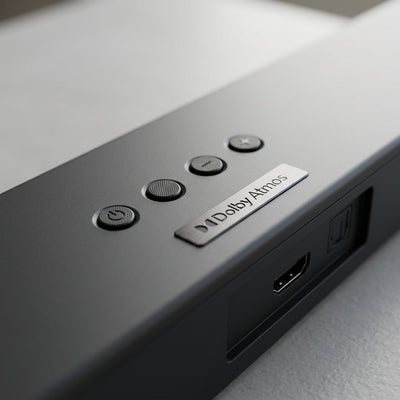 A macro view of the Sharp HT-SBW53121 soundbar, featuring detailed power, volume, and input buttons, along with visible HDMI and optical ports.