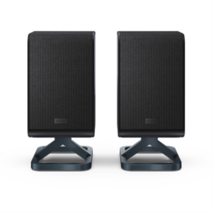 Pair of black Sharp wireless rear surround speakers with mesh grilles and angular desktop stands.