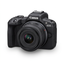 Photorealistic studio product photograph of the Canon EOS R50 camera with lens, angled left on a pure white background with a soft shadow.