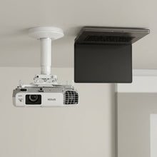 The EPSON ELPMBPJGV12H8 projector mount shown on a white wall above a large, closed 17-inch laptop, clearly illustrating the mount's precise scale against a familiar device.