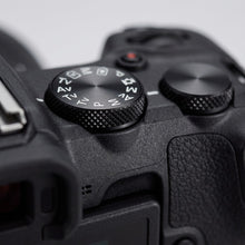 Macro close-up shot focusing on the textured control dial of the Canon EOS R50 camera.