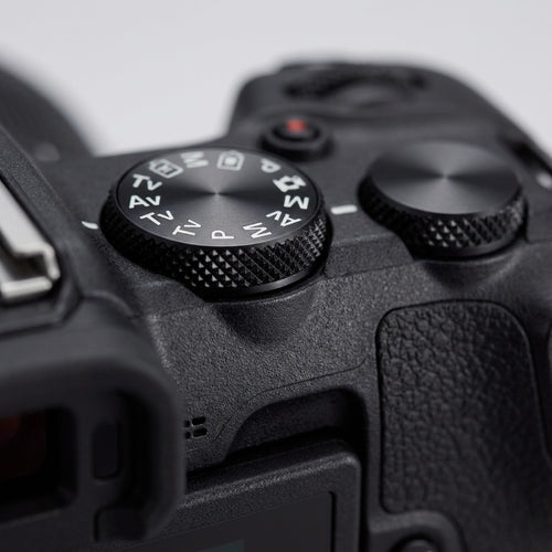 Macro close-up shot focusing on the textured control dial of the Canon EOS R50 V camera.