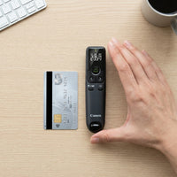 A photo of the Canon high-end PR10-G presenter next to a credit card on a wood table, showing its compact size for presentations.