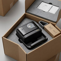 A realistic photo of the Dangbei DBOX02 Pro projector safely encased in custom protective foam within a box.