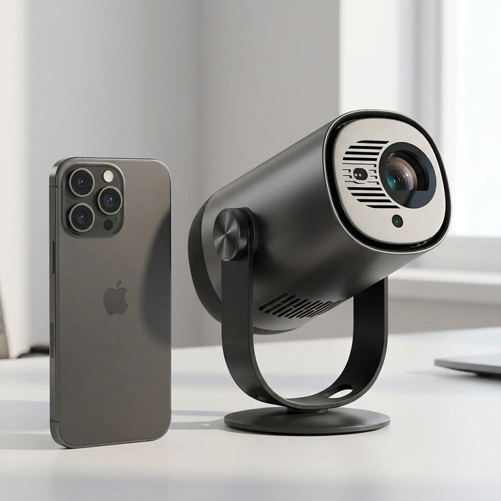 A scale photo of the dark gray Dangbei Freedo projector next to a smartphone on a white desk.