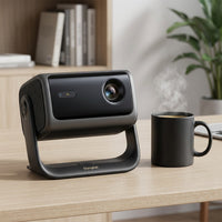 Scale reference: Dangbei MP1 Max projector on a modern desk beside a coffee mug, demonstrating its compact size.