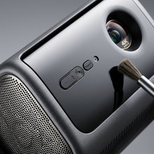 An extreme close-up photograph showcasing the complex multi-texture surface, the 4K Ultra HD lens detail, and the precise control buttons of the Dangbei MP1-Max projector.