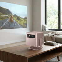 A Rose-colored Epson EF-22R laser projector sits on a modern wood table in a sunlit living room.