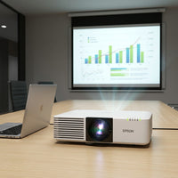 A close-up photograph of the white Epson PowerLite L500W laser projector, projecting a colorful graph onto a screen on a modern desk.