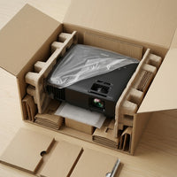 Black Epson PowerLite L265F projector in its open shipping box, wrapped in a plastic bag and cradled in moulded-pulp end-caps, with accessory boxes and a manual packed alongside.
