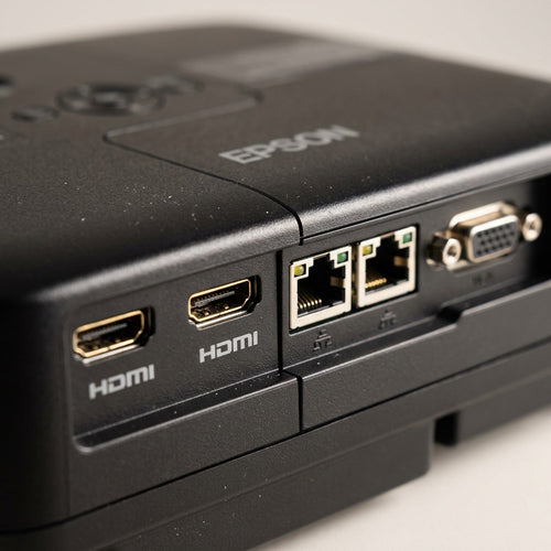 Macro photograph showing two gold-plated HDMI ports and two Ethernet ports on the Epson 805F projector.