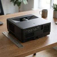 Size comparison: Black Epson projector on wooden desk with ruler, showing relative scale.