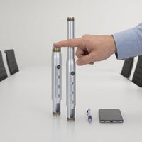 The Epson V12H810001 projector mount extension column, in a silver finish, is held near a person's hands and forearm for size reference in a clean workspace, highlighting its 9 to 12-inch adjustable length.