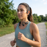 Close-up of OPN Sound Osso bone conduction headphones worn by a runner during an outdoor workout.